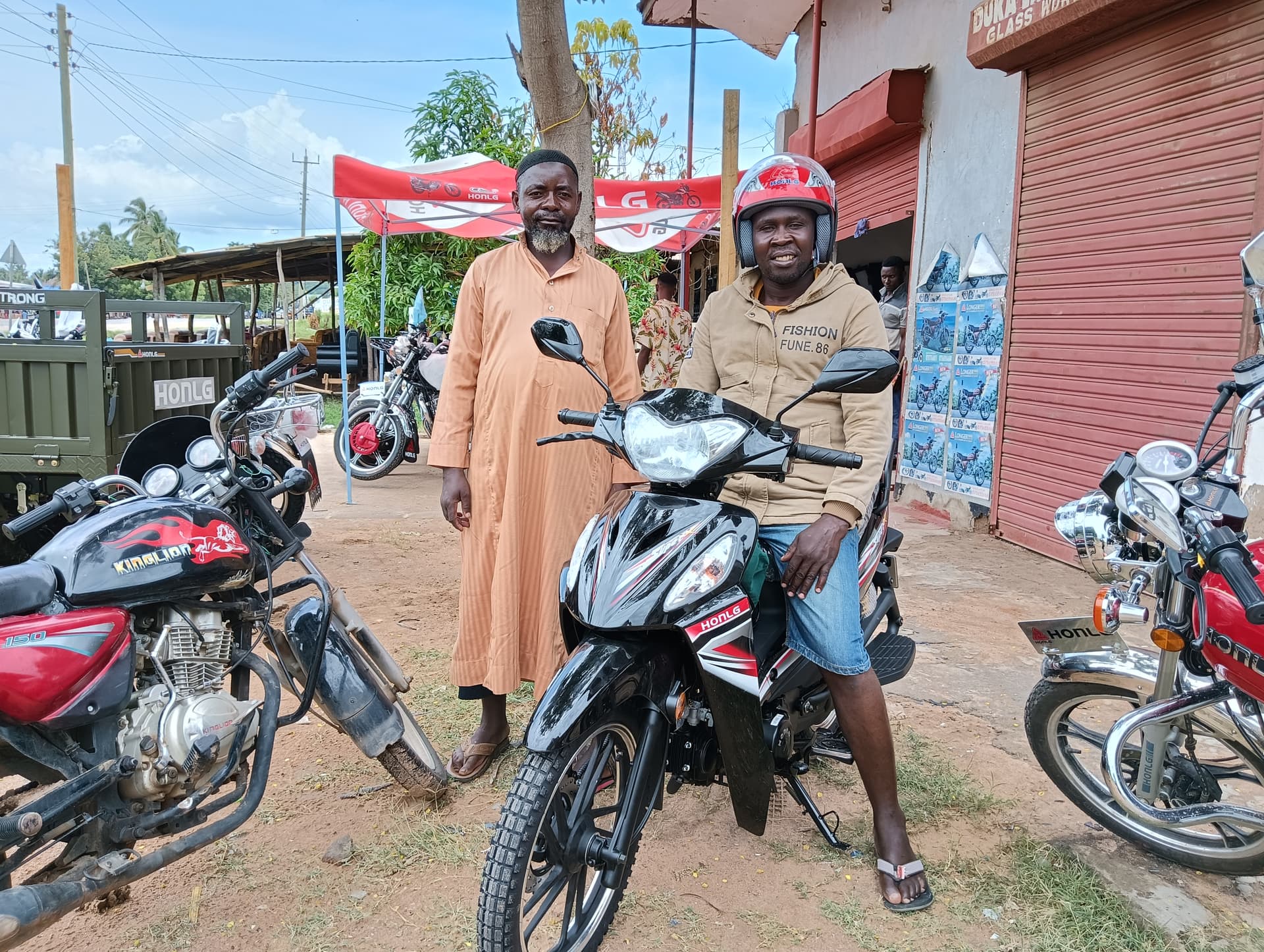 HONLG Tanzania customer with a motorcycle at a local retail location