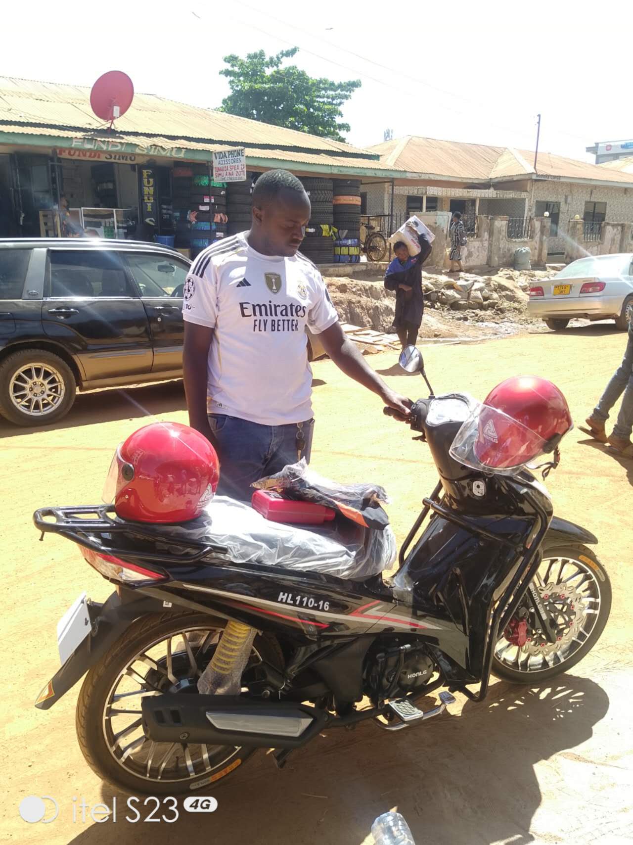 HONLG Tanzania rider standing beside a red HONLG motorcycle